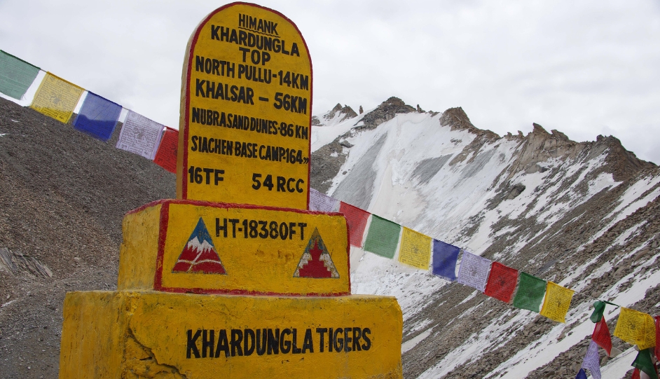Riders at Khardung La Pass sign